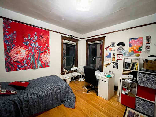 A bedroom with a bed, desk, and chair.