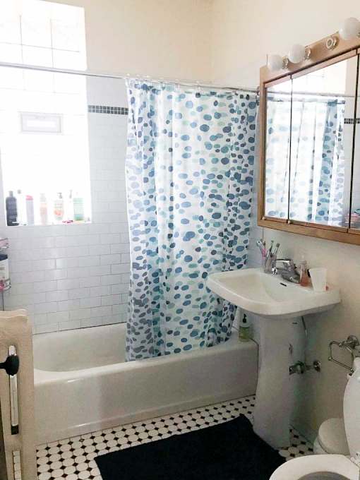A white sink is under a mirror in a bathroom with a black and white floor.