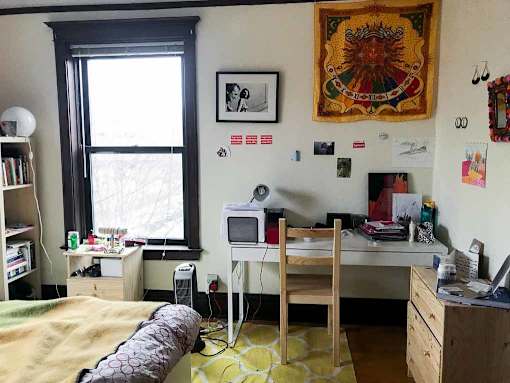 A room with a bed, desk, and chair.