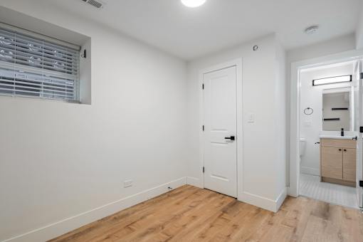 A white door is in a room with a wooden floor.
