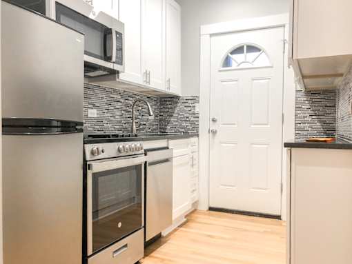 A kitchen with a white door and a black counter.