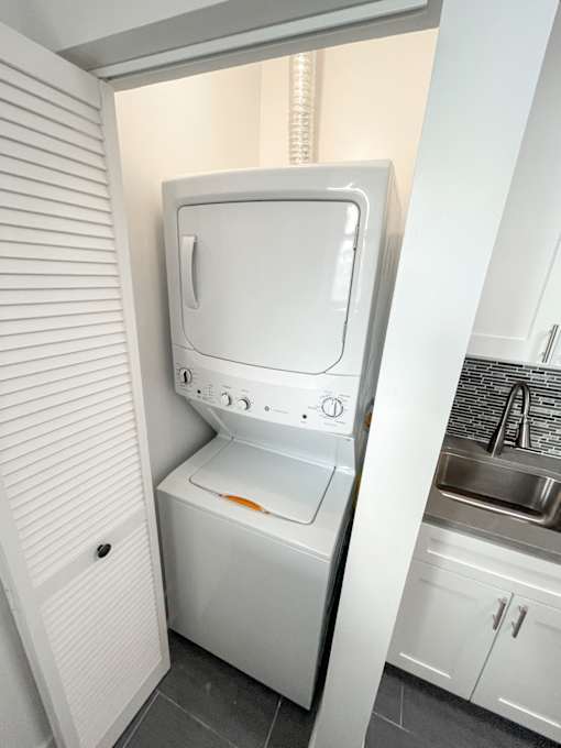 A white washing machine in a small laundry room.