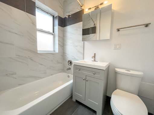 A white bathroom with a tub, toilet, and sink.