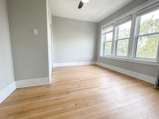 A room with wooden flooring and a window.