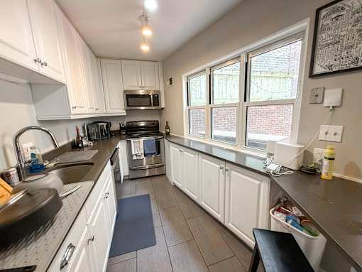 A kitchen with white cabinets and a black stove top.