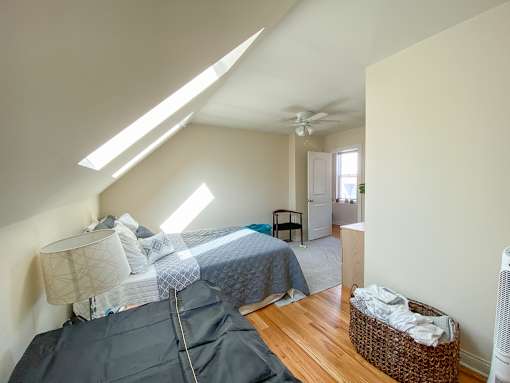 A room with a bed and a basket on the floor.
