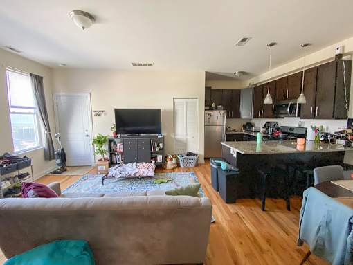 A living room with a couch and a kitchen in the background.