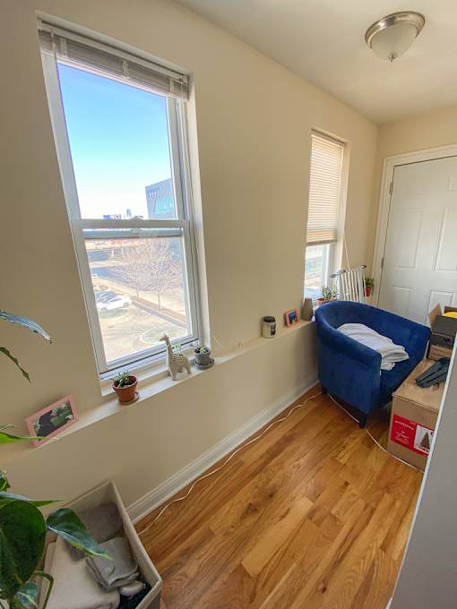 A room with a window and a blue chair.