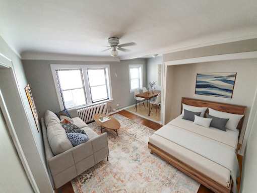 A bedroom with a bed, couch, and rug.