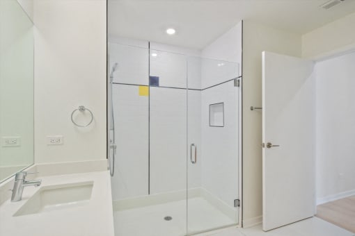 a white bathroom with a shower and a sink