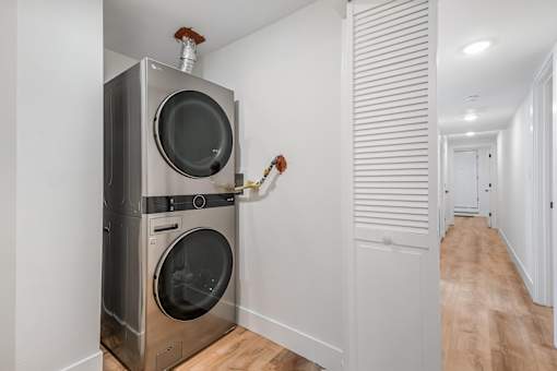 A modern laundry room with a washer and dryer built into the wall.
