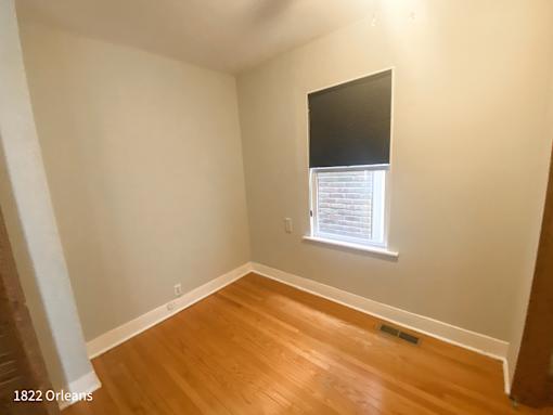 A room with a window and wooden flooring.