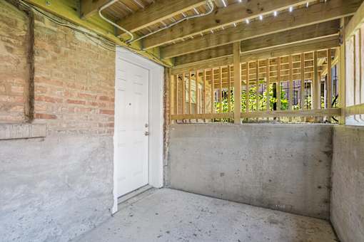 A room under construction with a white door and wooden beams.
