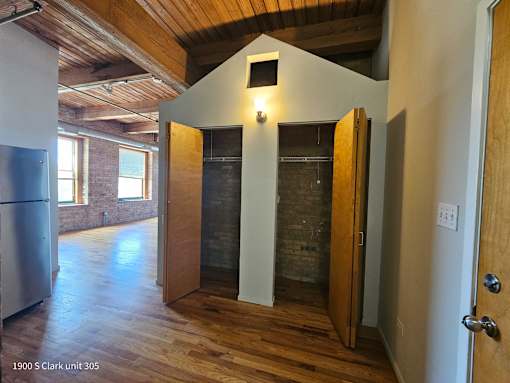 an empty living room with a vaulted ceiling and a walk in shower