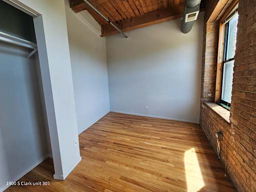 an empty room with wood floors and a window