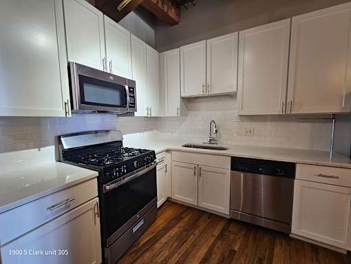 a kitchen with white cabinets and a stove and a microwave