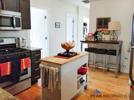 a kitchen with a island and a stove and a bar with stools