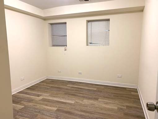 a room with wood flooring and two windows