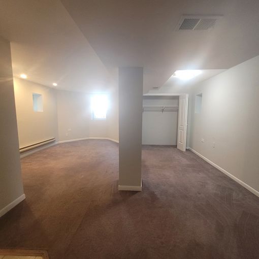 an empty living room with a carpeted floor and white walls