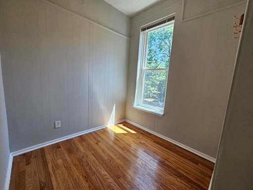 A room with wooden floors and a window.