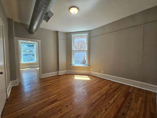A room with wooden floors and a window.