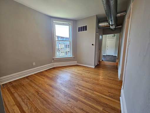 A room with wooden floors and a window.