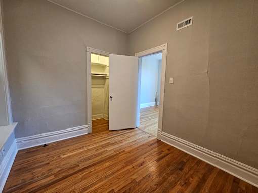 A room with a wooden floor and a white door.