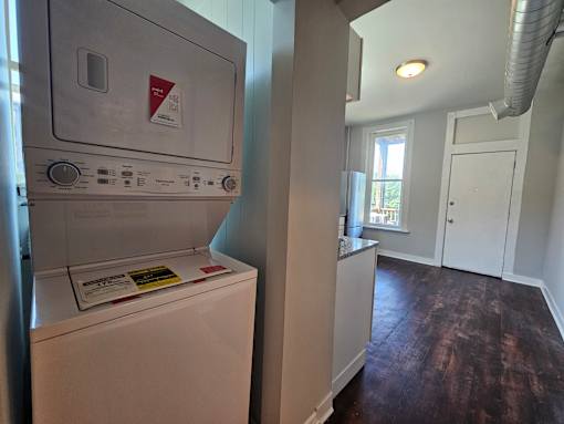 A washer and dryer in a small room with a door.