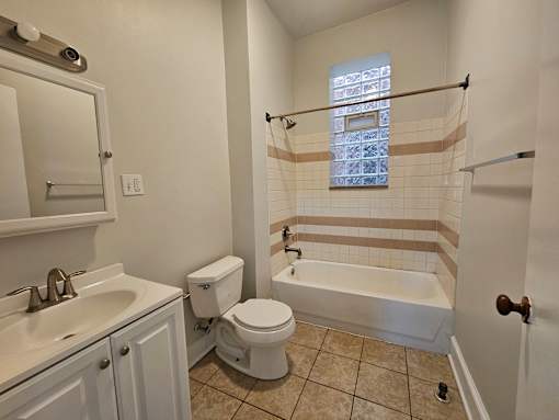 A white toilet sits next to a sink in a bathroom.