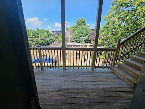 A wooden deck with a staircase leading to a house.