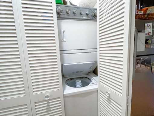 A white oven with a stove top and a stainless steel dishwasher is in a kitchen.