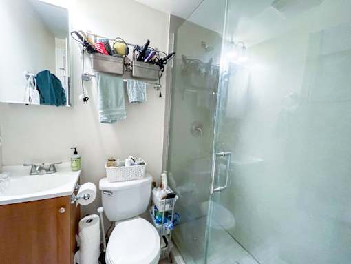 A bathroom with a toilet, sink, and shower.