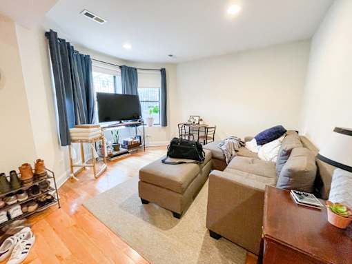 A living room with a grey couch and a television.