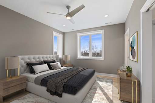 A bedroom with a large bed and a ceiling fan.