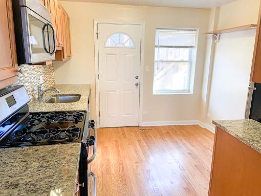 an empty kitchen with a stove and a white door