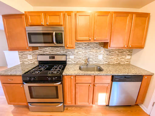 a kitchen with wooden cabinets and stainless steel appliances