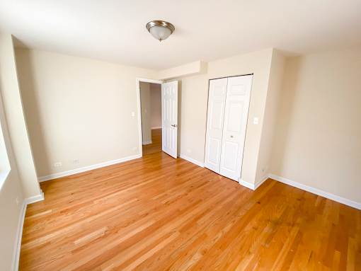 an empty living room with wood floors and white walls