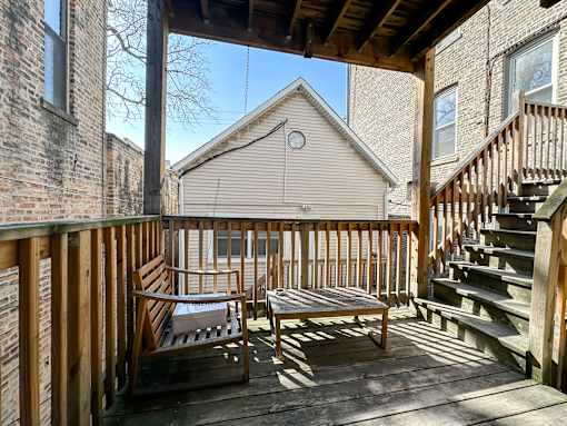 A wooden deck with a bench and a table.