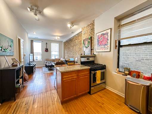 A kitchen with a stove top oven and a refrigerator.