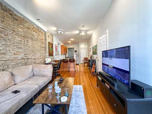 A living room with a couch, a coffee table, and a television.