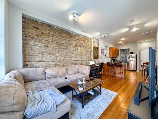 A living room with a brick wall and a couch.