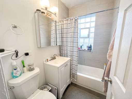 A white bathroom with a toilet, sink, and bathtub.