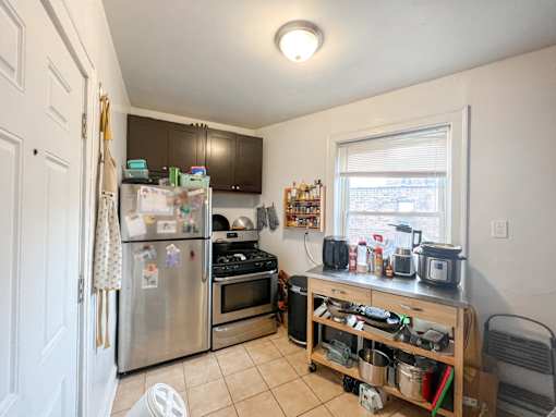 A kitchen with a refrigerator, oven, and microwave.