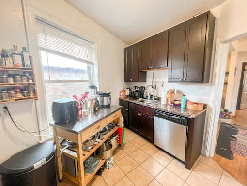 A kitchen with a black counter top and wooden cabinets.