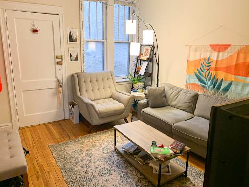 A living room with a grey couch, a white chair, and a coffee table.