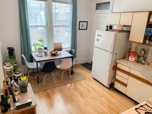 A kitchen with a table and chairs in front of a window.