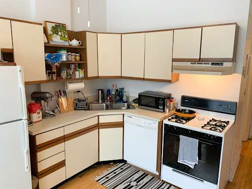 A kitchen with white appliances and wooden cabinets.