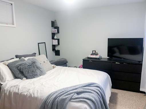 A bedroom with a bed, a dresser, and a TV.