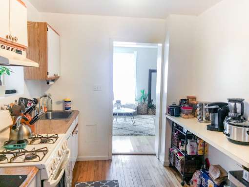 A kitchen with a stove top oven and a counter with a coffee maker on it.