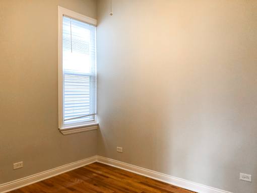 A room with a window and wooden floors.